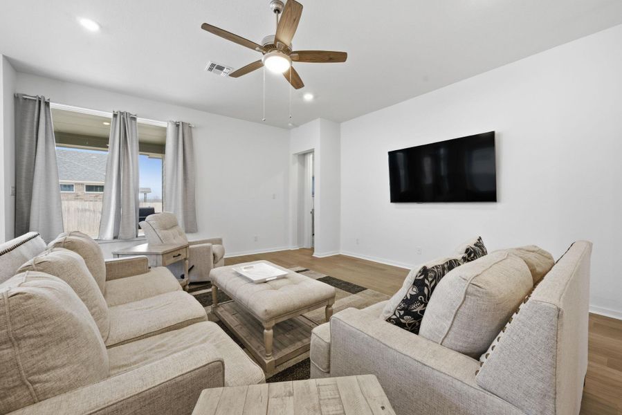 Living area with a ceiling fan, wood finished floors, and recessed lighting