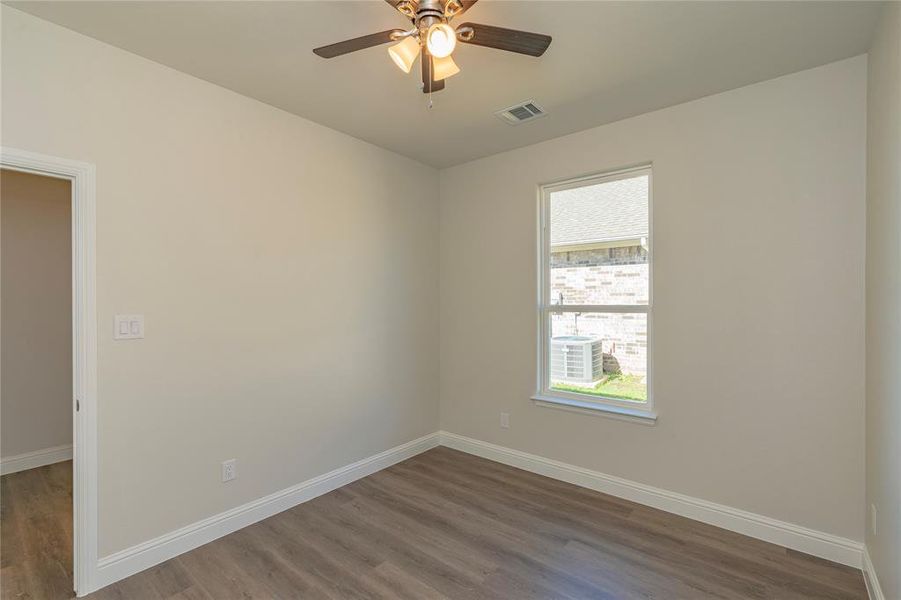 Spare room with dark hardwood / wood-style floors and ceiling fan