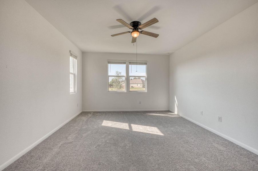 Plentiful natural light streams across plush carpeting from multiple large windows.