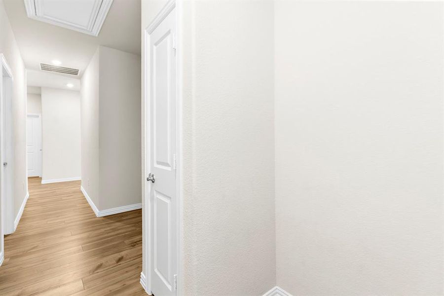 Corridor with light wood-style floors and recessed lighting Corridor with light wood-style floors and recessed lighting