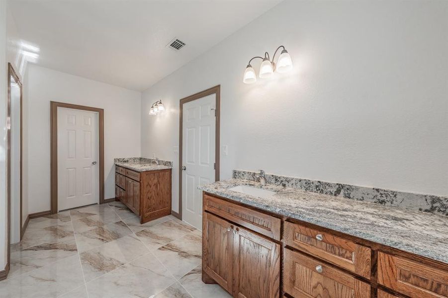 Bathroom with marble finish floor, visible vents, vanity, and baseboards