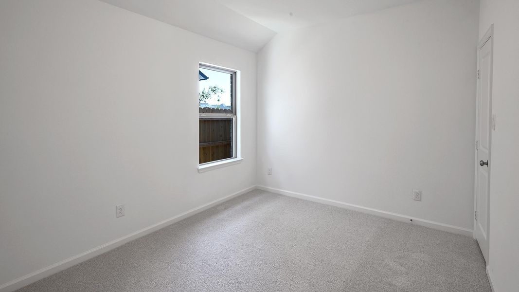 Empty room featuring light colored carpet and vaulted ceiling Empty room featuring light colored carpet and vaulted ceiling