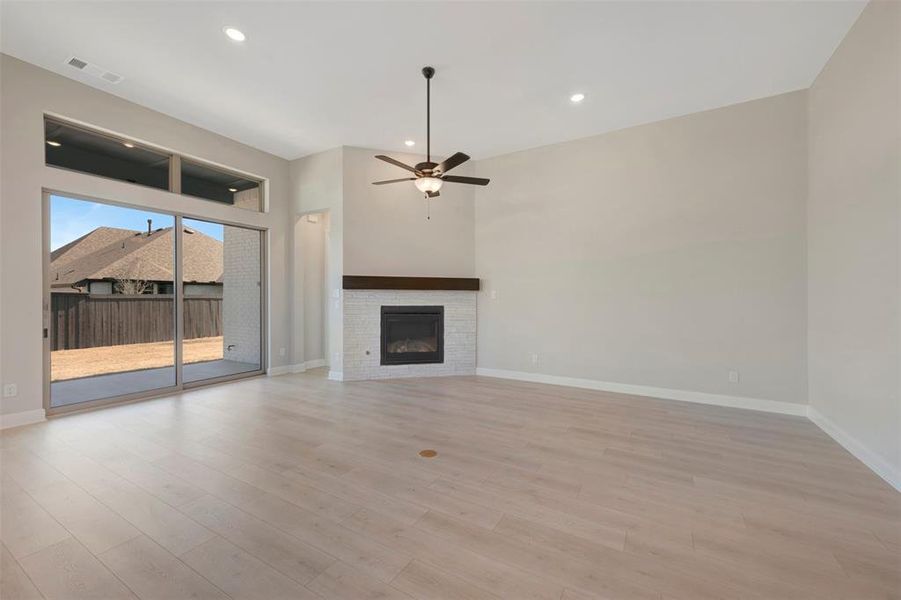 Unfurnished living room featuring a glass covered fireplace, a ceiling fan, light wood-style floors, and recessed lighting Unfurnished living room featuring a glass covered fireplace, a ceiling fan, light wood-style floors, and recessed lighting