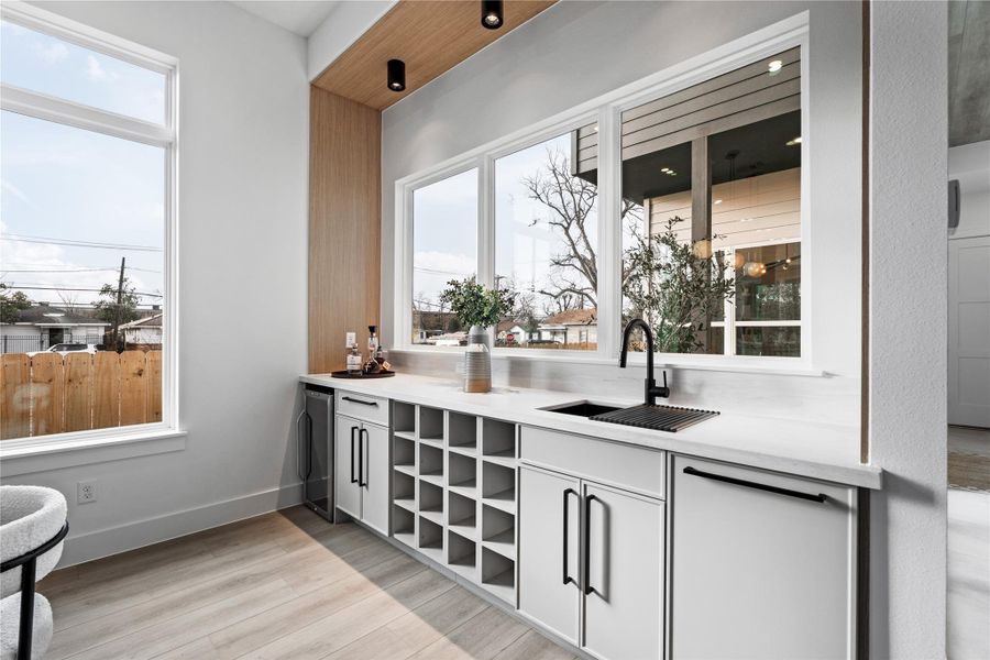 Set apart yet fully integrated, this bar area creates a quiet moment between kitchen and patio. Sunlit surfaces and tailored cabinetry make it as practical as it is polished.