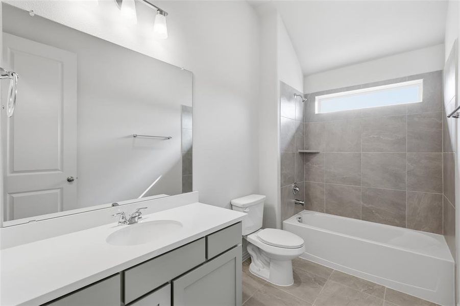 Bathroom featuring a white vanity with an integrated sink, polished chrome faucet, and expansive mirror Bathroom featuring a white vanity with an integrated sink, polished chrome faucet, and expansive mirror