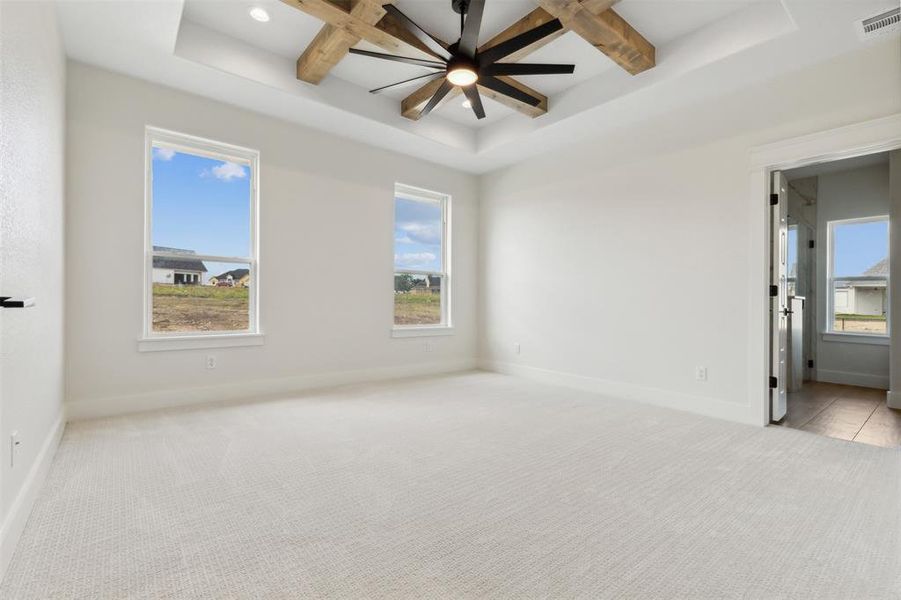 Spare room featuring plenty of natural light, beam ceiling, and ceiling fan