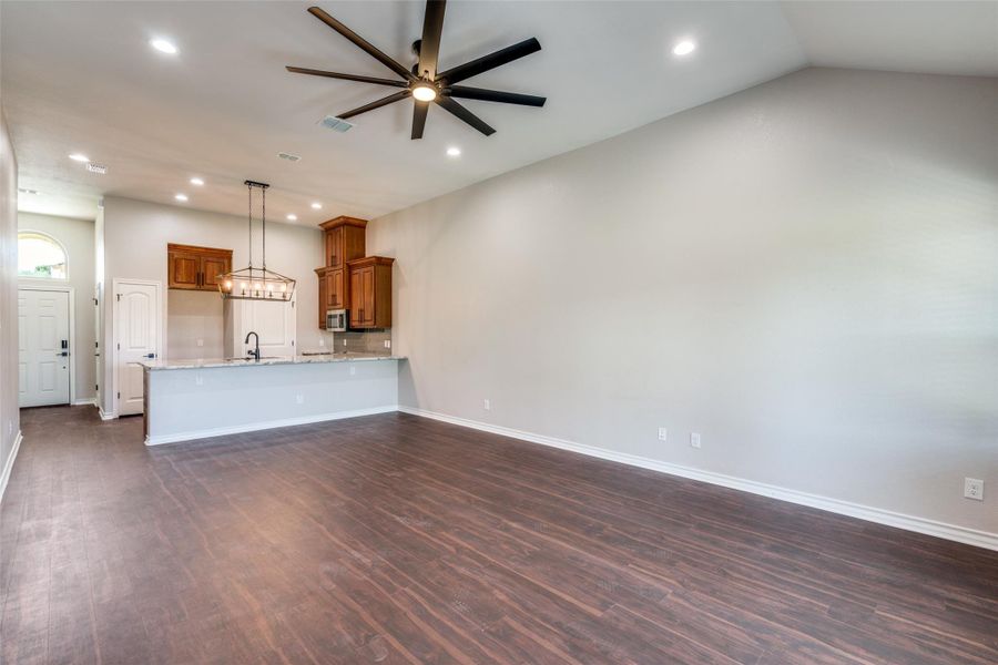 Unfurnished living room featuring dark wood-style floors, recessed lighting, and a ceiling fan Unfurnished living room featuring dark wood-style floors, recessed lighting, and a ceiling fan