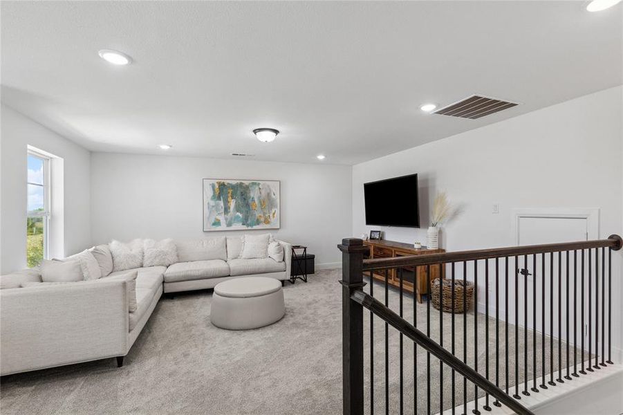 Living room featuring recessed lighting, visible vents, carpet flooring, and baseboards Living room featuring recessed lighting, visible vents, carpet flooring, and baseboards