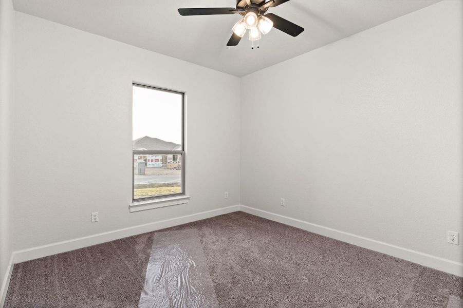 Unfurnished room with carpet floors and a ceiling fan Unfurnished room with carpet floors and a ceiling fan