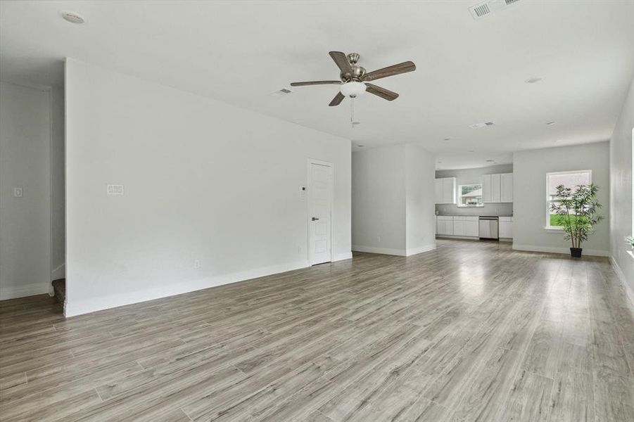 Unfurnished living room with light wood-type flooring and ceiling fan