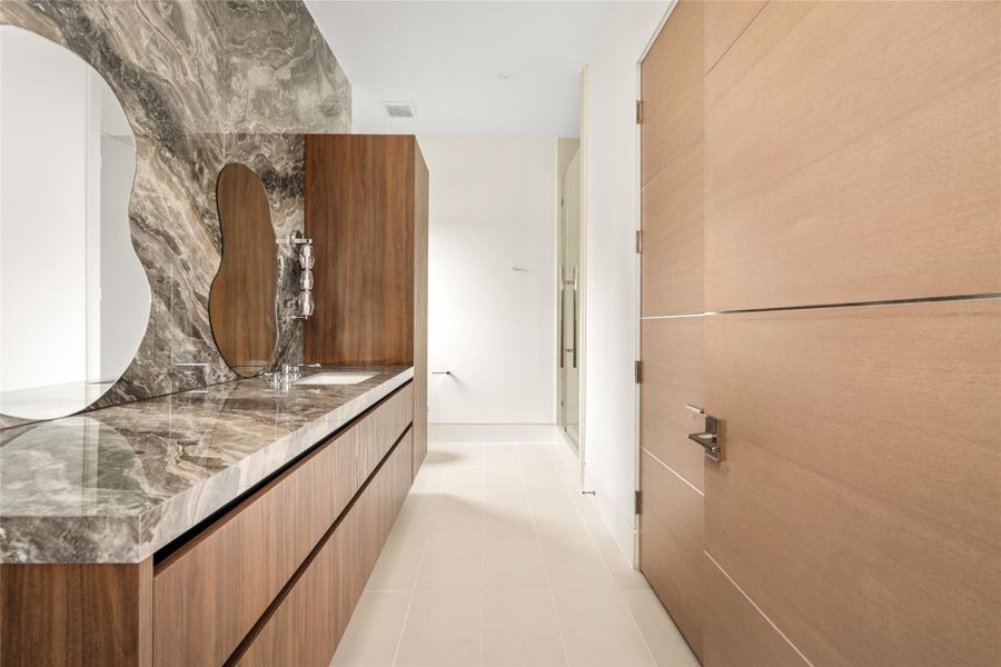 Architectural vanity featuring a full-height stone slab and refined modern finishes