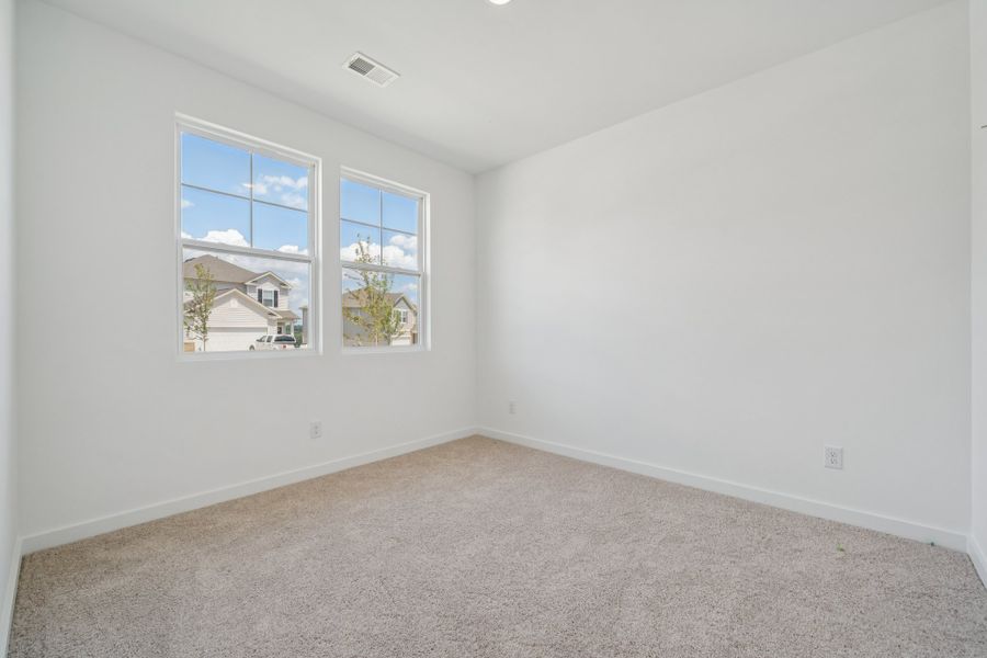 A room with a window and a carpet.