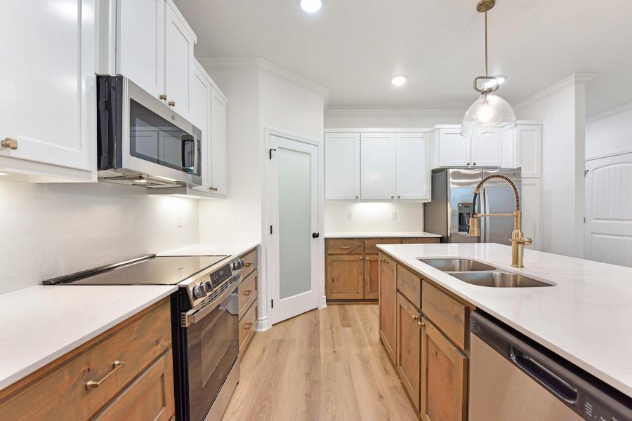 Culinary delights await in this bright kitchen, showcasing an inviting island and stunning pendant lighting. Culinary delights await in this bright kitchen, showcasing an inviting island and stunning pendant lighting.