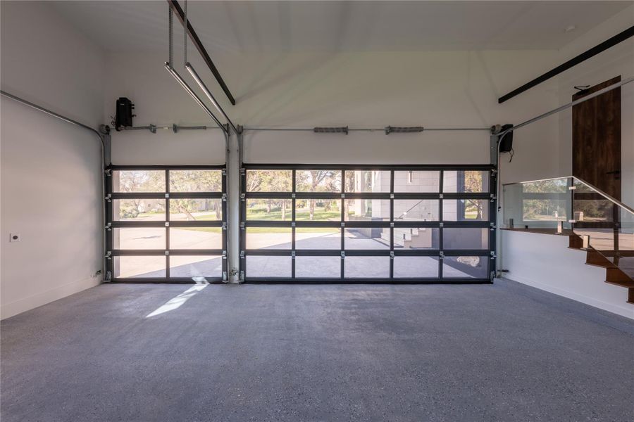 Two glass-paneled garage doors offer abundant natural light to this spacious, well-maintained garage interior.