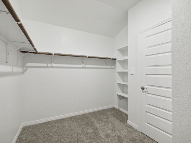 The large primary bedroom closet has lots of room for clothes and storage.