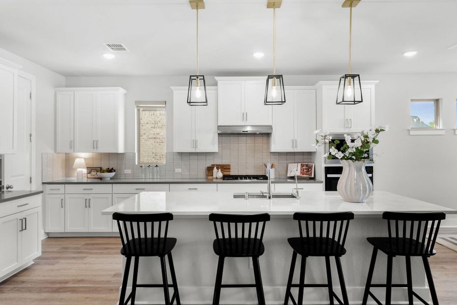 Culinary dreams come alive in this well-appointed kitchen, featuring a spacious island with seating and gleaming appliances.