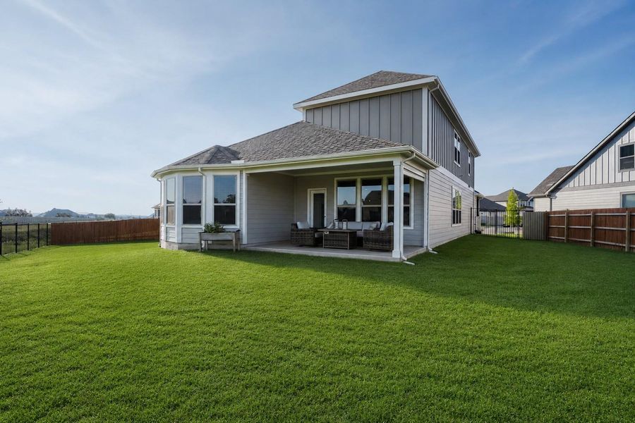 A spacious backyard with a covered patio offers ample room for outdoor activities and gatherings. A spacious backyard with a covered patio offers ample room for outdoor activities and gatherings.