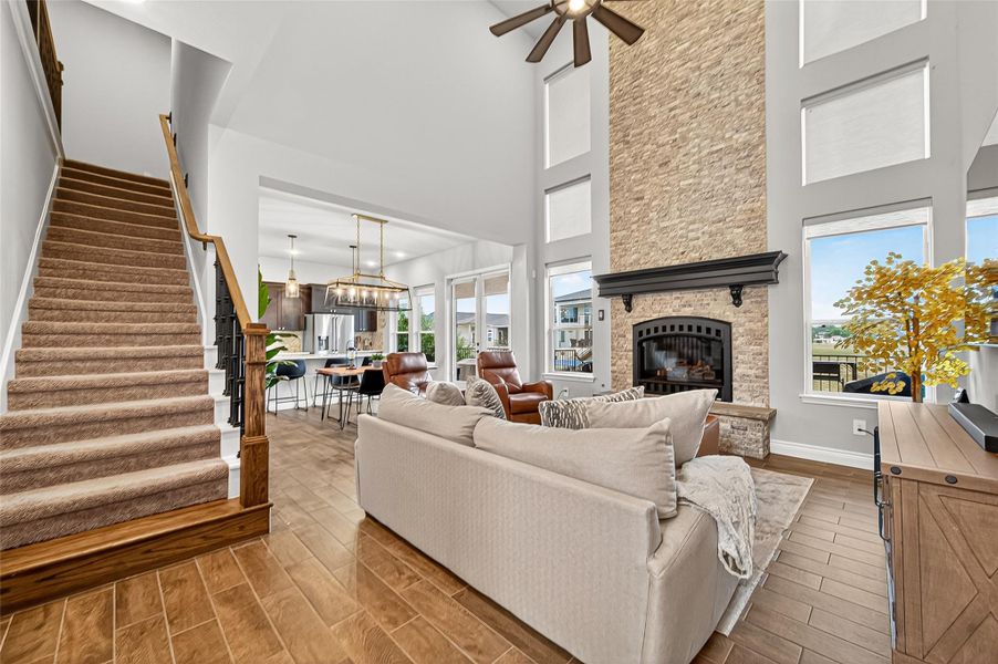 Spacious family room with open sight lines to the kitchen and dining area. Elegant iron-spindle staircase and balcony railing add architectural interest. Spacious family room with open sight lines to the kitchen and dining area. Elegant iron-spindle staircase and balcony railing add architectural interest.