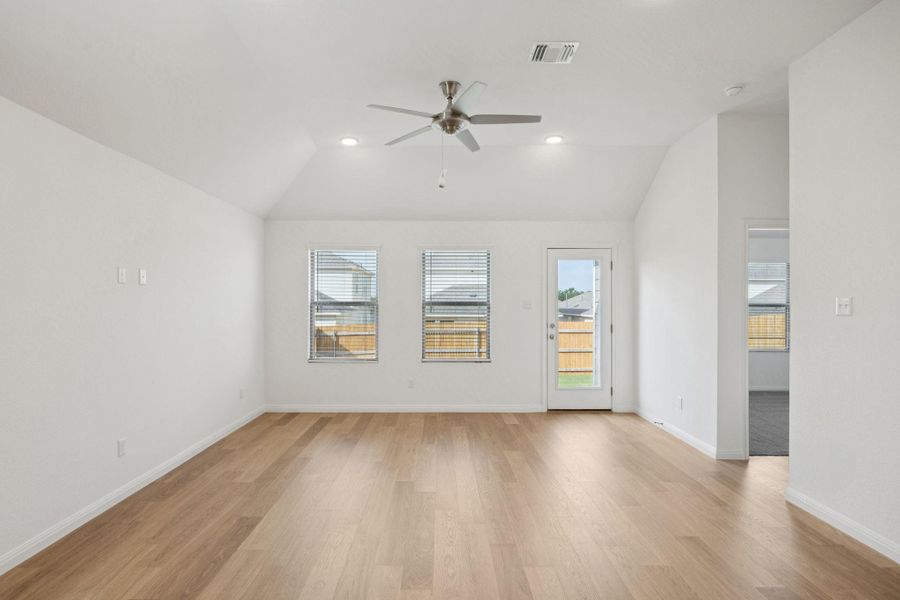 Unfurnished room featuring a ceiling fan, plenty of natural light, vaulted ceiling, light wood finished floors, and recessed lighting