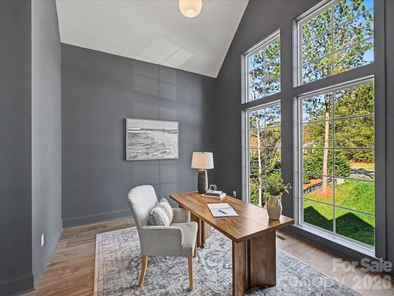 Private home office with soaring ceilings and oversized windows, offering abundant natural light and an inspiring workspace.