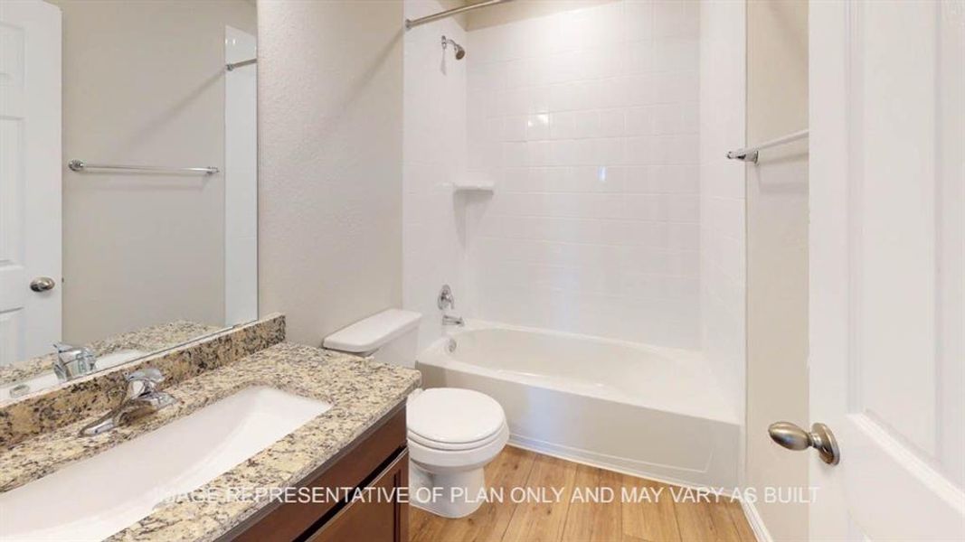 Bathroom with toilet, wood finished floors, vanity, and bathtub / shower combination Bathroom with toilet, wood finished floors, vanity, and bathtub / shower combination