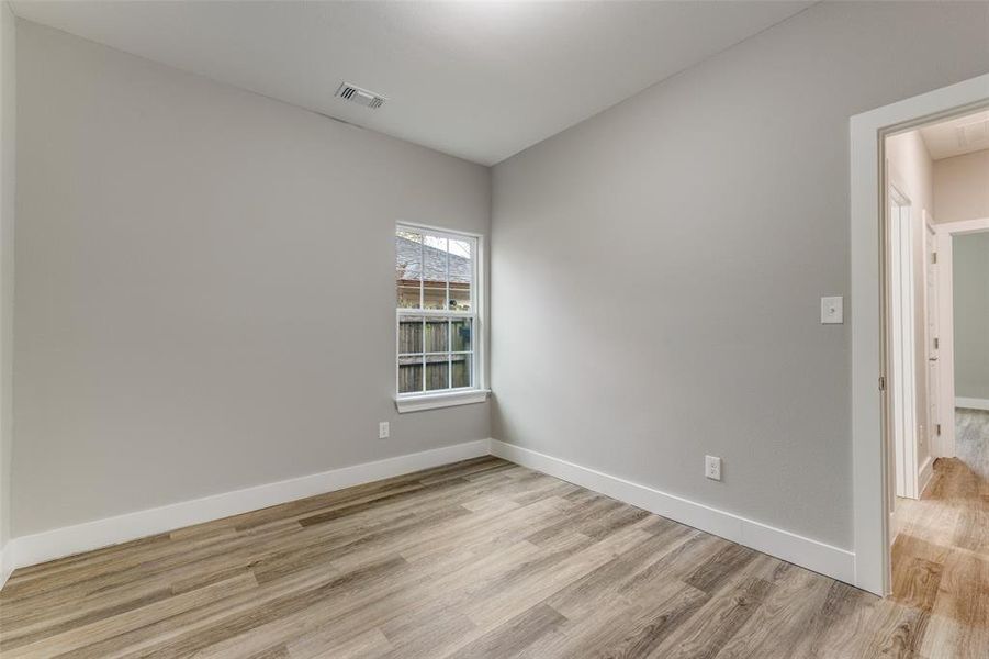 Unfurnished room with light wood-style floors and baseboards