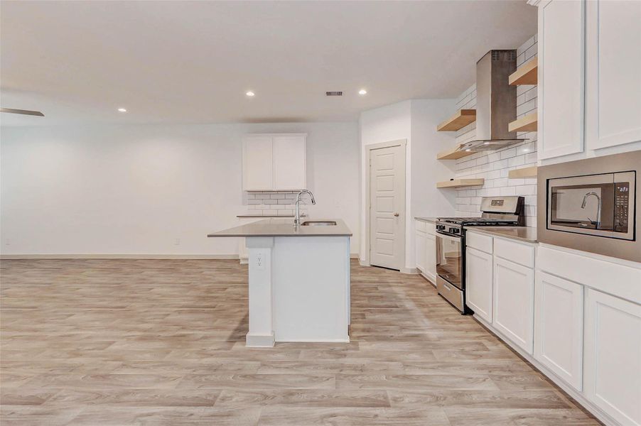 Enjoy effortless entertaining in this contemporary kitchen featuring quartz countertops, subway tile backsplash, and stainless steel appliances. The oversized island with undermount sink offers both prep space and casual dining, while the walk-in pantry provides plenty of storage just steps away. Enjoy effortless entertaining in this contemporary kitchen featuring quartz countertops, subway tile backsplash, and stainless steel appliances. The oversized island with undermount sink offers both prep space and casual dining, while the walk-in pantry provides plenty of storage just steps away.