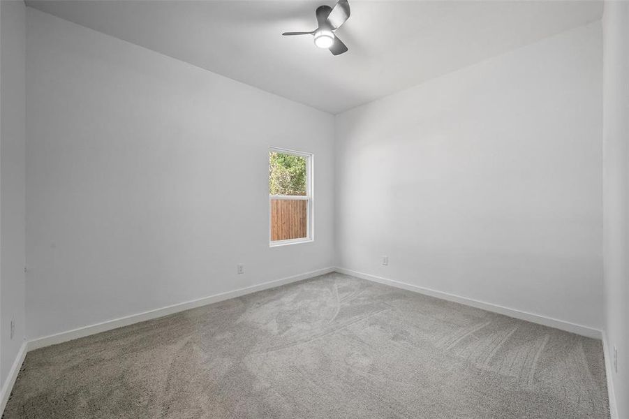 Spare room featuring light carpet and a ceiling fan Spare room featuring light carpet and a ceiling fan
