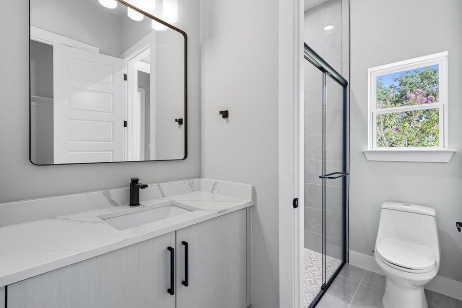 Bathroom featuring vanity, a shower stall, and light tile patterned flooring