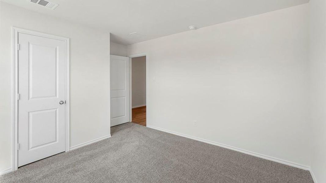 Neutral-toned room featuring light gray carpet flooring and white painted walls
