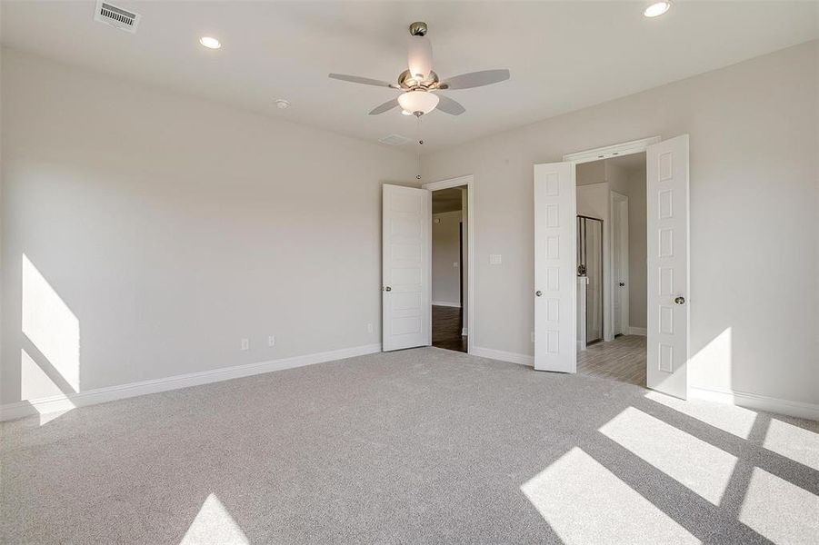 Unfurnished bedroom with light colored carpet and ceiling fan