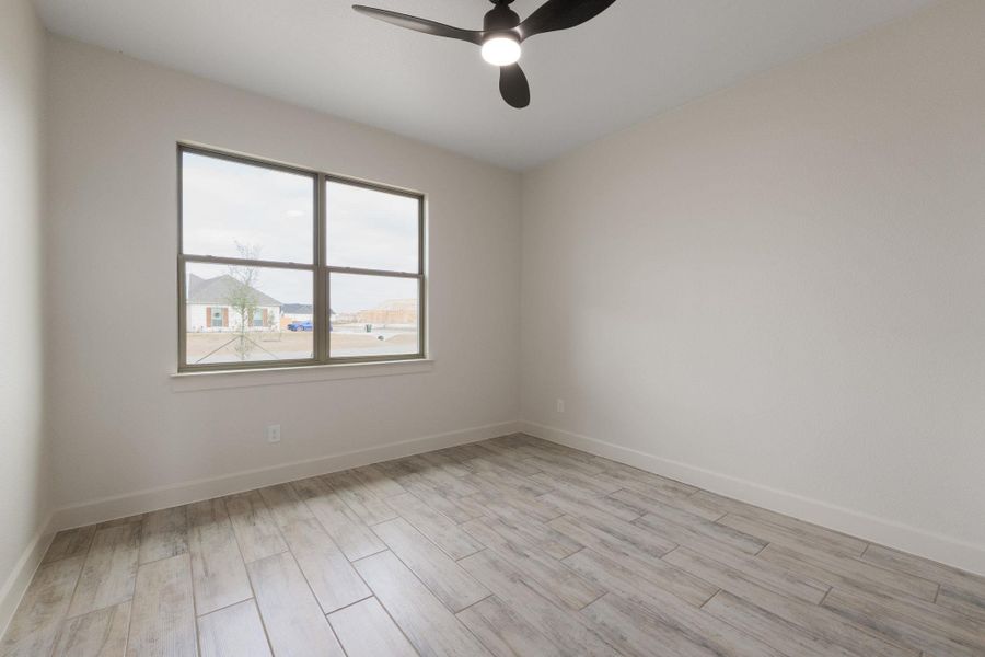 Empty room with wood tiled floors and ceiling fan