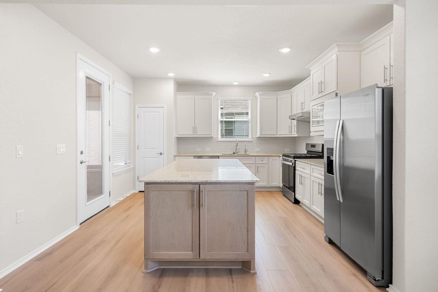A contemporary kitchen showcasing light wood flooring and bright cabinetry, centered around a spacious island. A contemporary kitchen showcasing light wood flooring and bright cabinetry, centered around a spacious island.