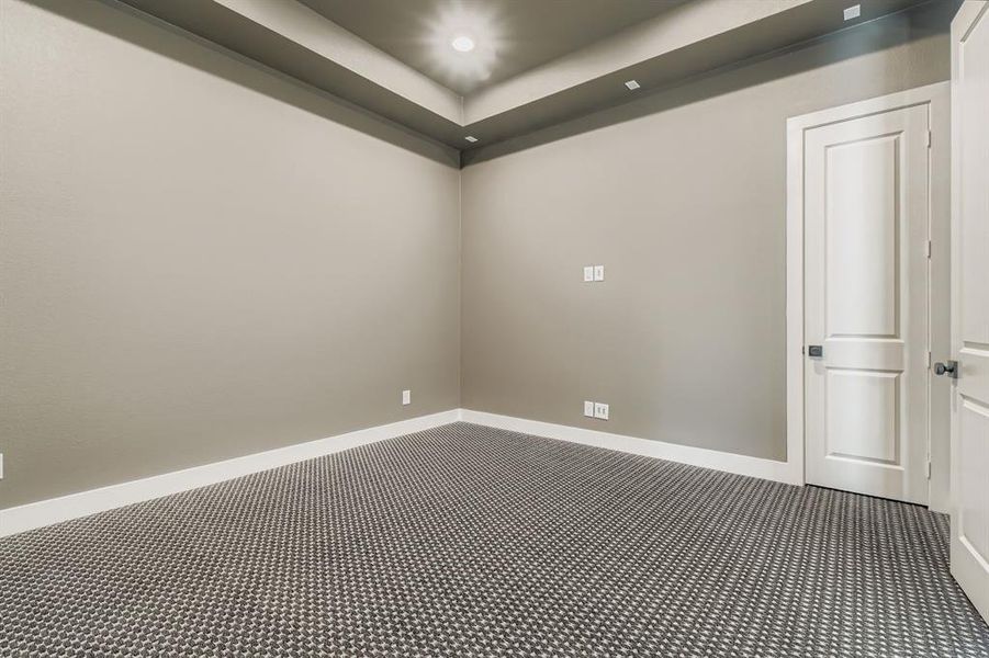 Carpeted empty room featuring a raised ceiling and recessed lighting Carpeted empty room featuring a raised ceiling and recessed lighting