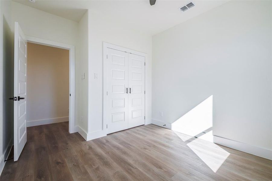 Unfurnished bedroom with hardwood / wood-style floors, a closet, and ceiling fan