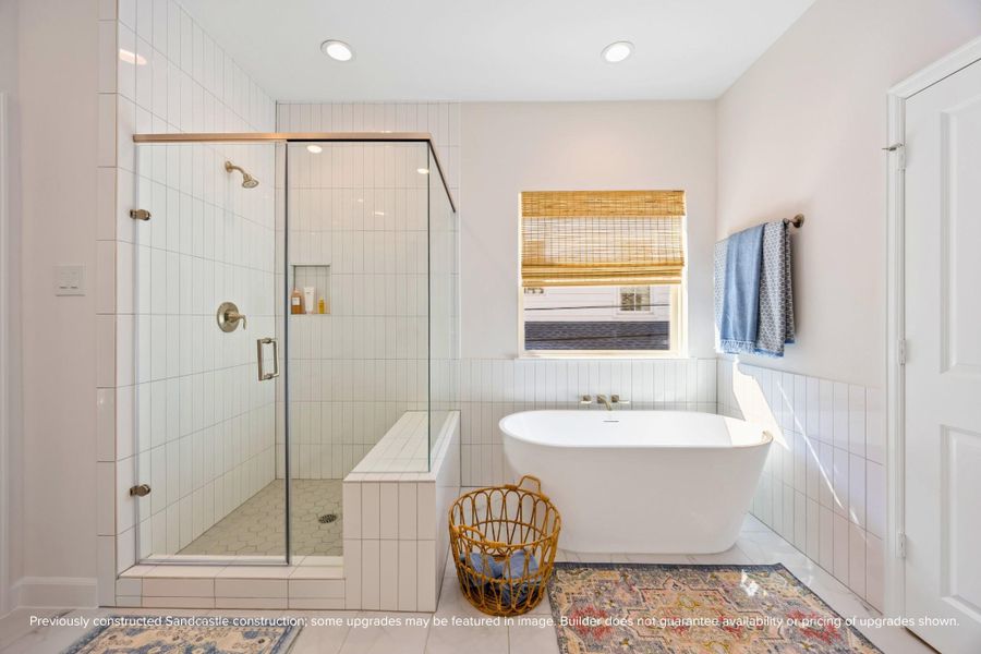A freestanding tub and oversized walk-in shower turn your daily routine into a spa-worthy experience—complete with designer tile and built-in storage.