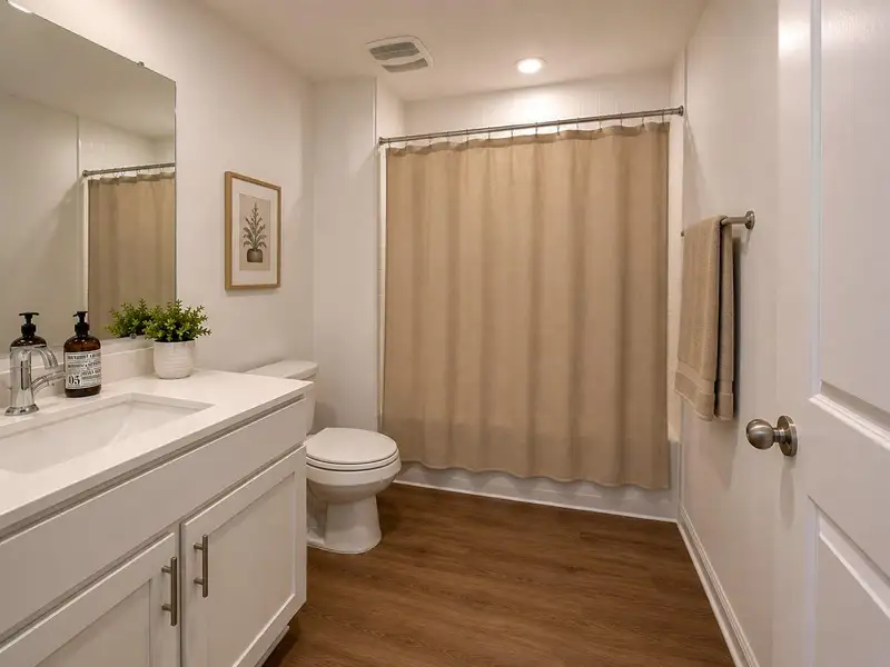 A well-appointed bath features rich LVP flooring, a spacious vanity, and a shower with a light-colored curtain. A well-appointed bath features rich LVP flooring, a spacious vanity, and a shower with a light-colored curtain.