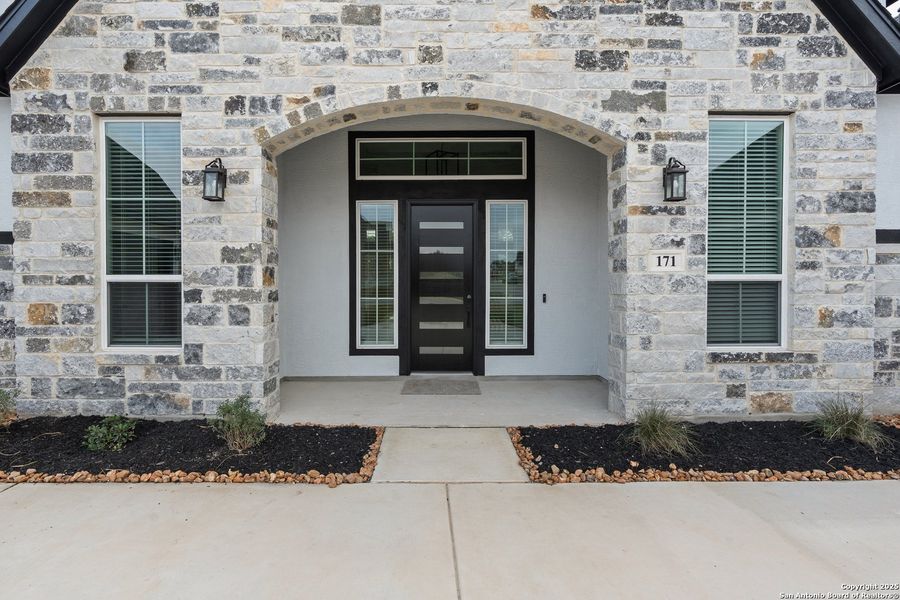 Front exterior of a new home in Potranco Oaks, Castroville, TX, highlighting curb appeal (Image 1). Front exterior of a new home in Potranco Oaks, Castroville, TX, highlighting curb appeal (Image 1).