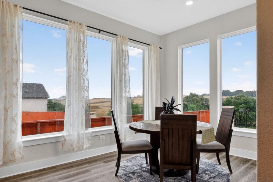 Dining area featuring multiple tall windows with expansive outdoor scenery Dining area featuring multiple tall windows with expansive outdoor scenery