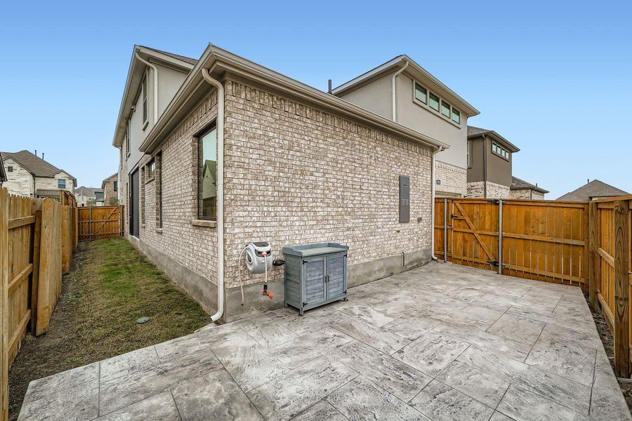 View of side of property with brick siding, a fenced backyard, and a gate View of side of property with brick siding, a fenced backyard, and a gate