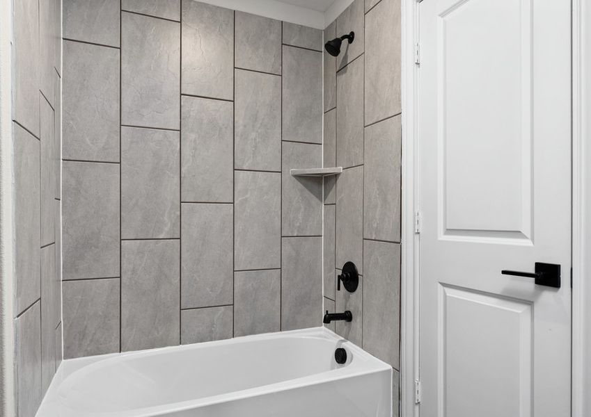The secondary bathroom has a tiled, shower-tub combo.