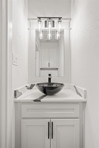 Bathroom featuring a textured wall and vanity Bathroom featuring a textured wall and vanity