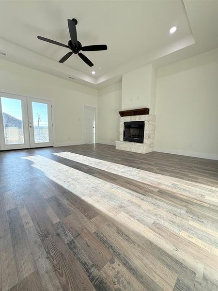 Open concept living room with fire wood and burning place and whit brick. Tray ceilings and 10' ceiling.  Luxury vinyl living room flooring and throughout the entire house.
