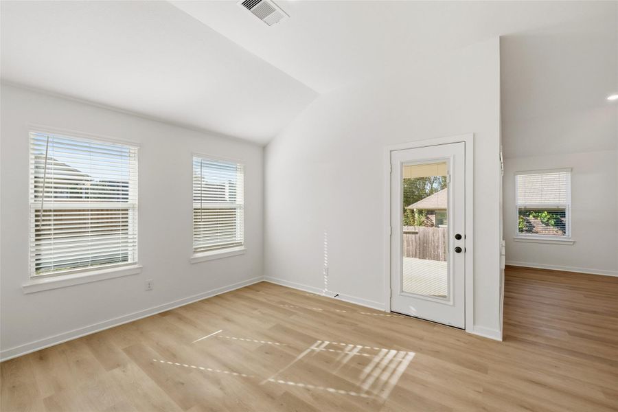 A view of the dining area and rear access to the covered back patio. Notice the hidden blinds in the backdoor.
