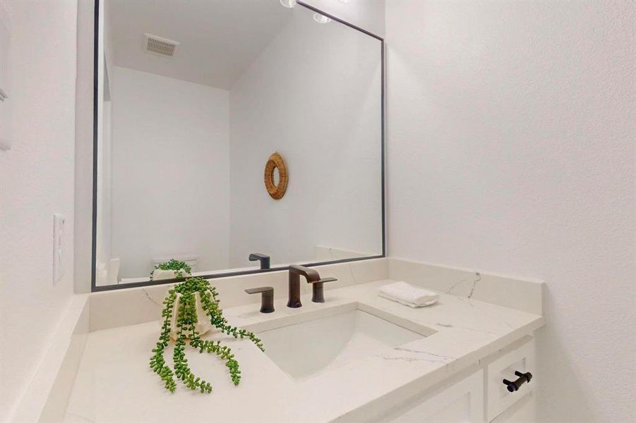 Half bathroom featuring vanity and toilet Half bathroom featuring vanity and toilet