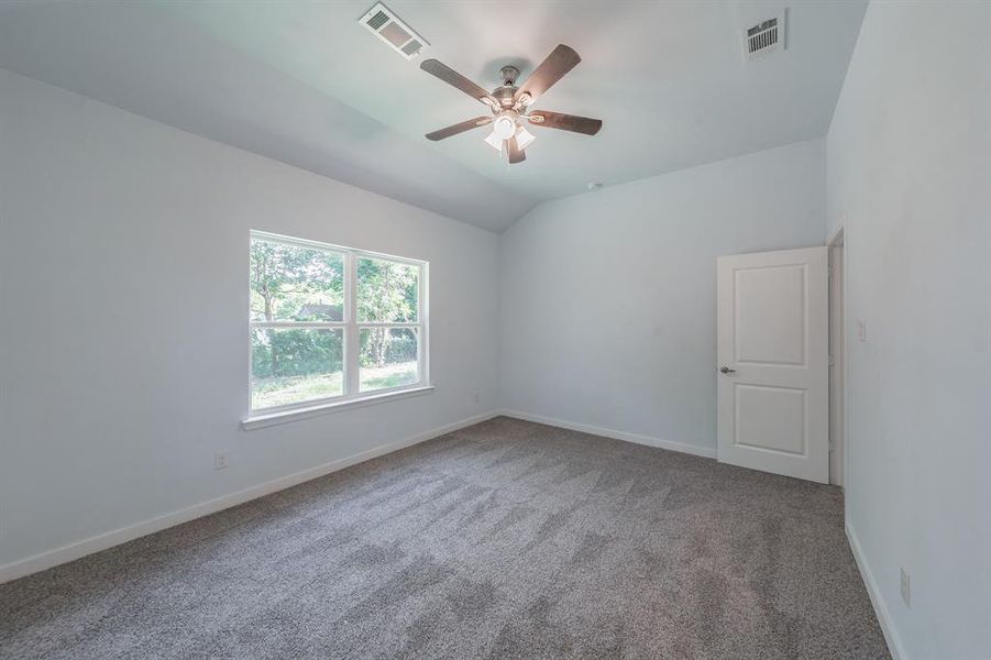 Empty room featuring carpet floors, a ceiling fan, and lofted ceiling Empty room featuring carpet floors, a ceiling fan, and lofted ceiling