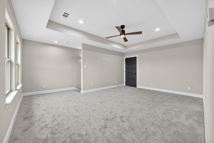 Expansive room featuring plush gray carpeting, neutral wall paint, and white trim