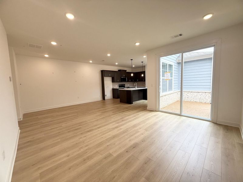 Unfurnished living room featuring light wood-type flooring, recessed lighting, baseboards, and a sink Unfurnished living room featuring light wood-type flooring, recessed lighting, baseboards, and a sink