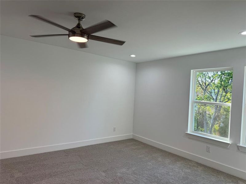 Carpeted empty room with ceiling fan