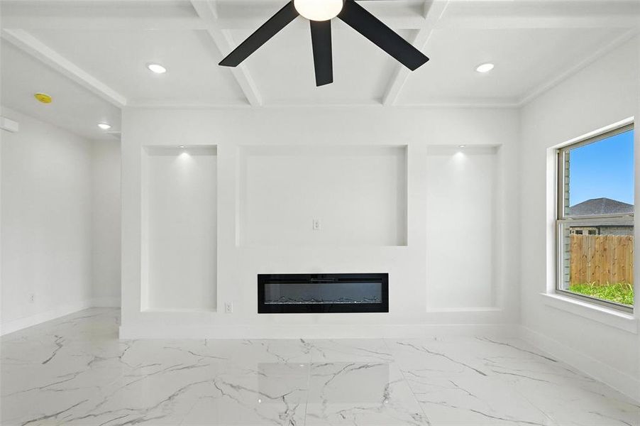 Unfurnished living room featuring marble finish flooring, recessed lighting, a glass covered fireplace, a ceiling fan, and beam ceiling